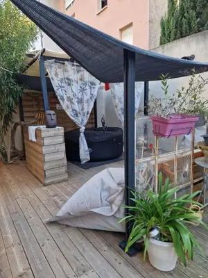 a black patio umbrella on a deck with plants at studio domloc in Carcassonne