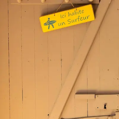 a yellow sign on a building with a surfboard on it at studio domloc in Carcassonne