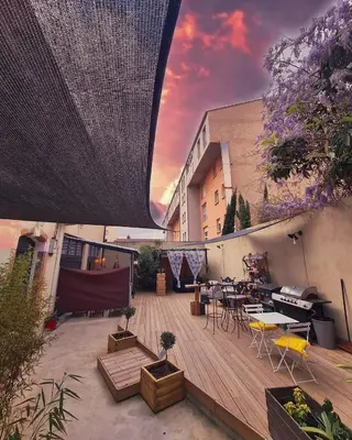a patio with a table and chairs and a building at studio domloc in Carcassonne