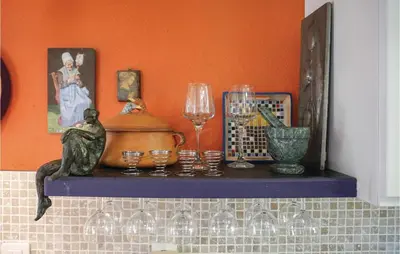 a shelf with wine glasses and a statue on it at Lovely Home In Puisserguier With Wifi in Puisserguier