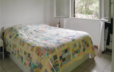 a bed with a blanket on it in a bedroom at Lovely Home In Puisserguier With Wifi in Puisserguier