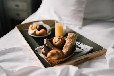 a tray of food with bread and a glass of orange juice at Hôtel La Résidence in Narbonne