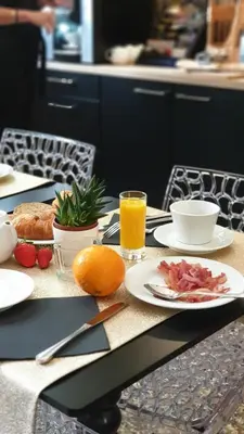 a table with plates of food and a glass of orange juice at Hôtel La Résidence in Narbonne