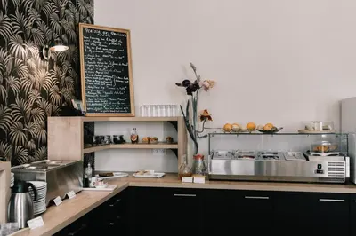 a kitchen with a counter with a chalkboard on the wall at Hôtel La Résidence in Narbonne