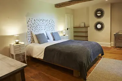 a bedroom with a large bed with blue pillows at Chambres d'hôtes du Domaine de Bonnery in Caucalières