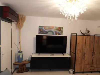 a living room with a large television and a chandelier at Casa Del Castell in Carcassonne