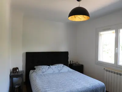 a bedroom with a bed with a black headboard and a light at Casa Del Castell in Carcassonne