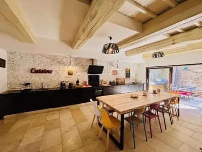 a kitchen and dining room with a wooden table and chairs at Olonzac Escape Pool & Charm in Olonzac