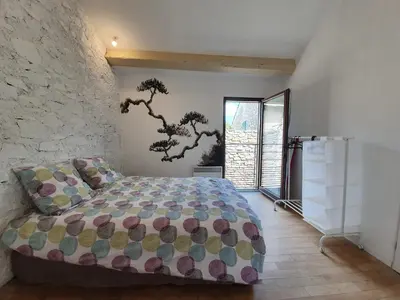 a bedroom with a bed and a stone wall at Olonzac Escape Pool & Charm in Olonzac