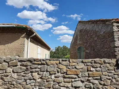 a stone wall next to a building and a house at Olonzac Escape Pool & Charm in Olonzac