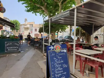 a restaurant with tables and chairs and a sign at Olonzac Escape Pool & Charm in Olonzac