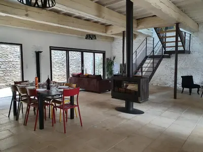 a living room with a table and a fireplace at Olonzac Escape Pool & Charm in Olonzac