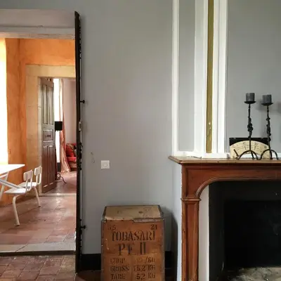 a living room with a fireplace and a box at La Manufacture Royale 1739 in Montolieu