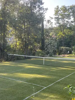 a tennis net on a tennis court with trees at La Manufacture Royale 1739 in Montolieu