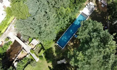 an overhead view of a swimming pool with trees at La Manufacture Royale 1739 in Montolieu