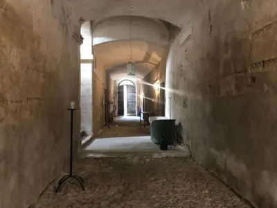 an empty hallway in an old building with a window at La Manufacture Royale 1739 in Montolieu