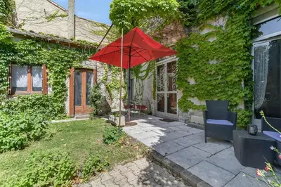 a red umbrella in the yard of a house at Les Bellevue Cité 