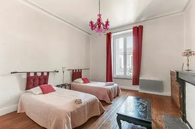 a bedroom with two beds and a fireplace at Les Bellevue Cité 