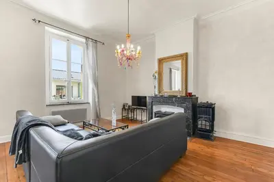 a living room with a couch and a chandelier at Les Bellevue Cité 