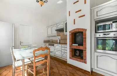 a kitchen with a dining table and a fireplace at Les Bellevue Cité 