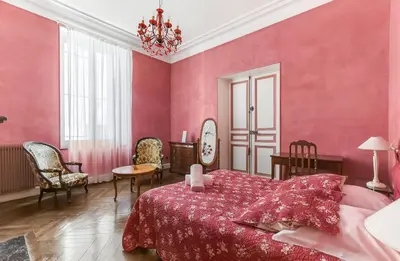 a pink bedroom with a bed and a table and chairs at Les Bellevue Cité 
