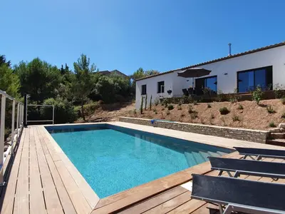 a swimming pool with a wooden deck and a house at Stylish villa in Beaufort with private pool in Beaufort