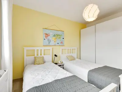 two beds in a bedroom with yellow walls at Stylish villa in Beaufort with private pool in Beaufort