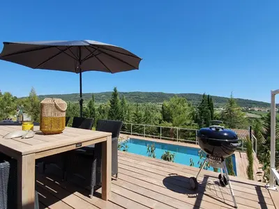 a grill on a table with an umbrella on a deck at Stylish villa in Beaufort with private pool in Beaufort