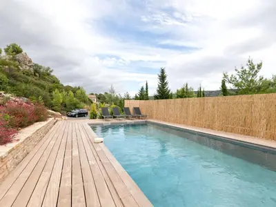 a swimming pool with chairs and a wooden deck at Stylish villa in Beaufort with private pool in Beaufort