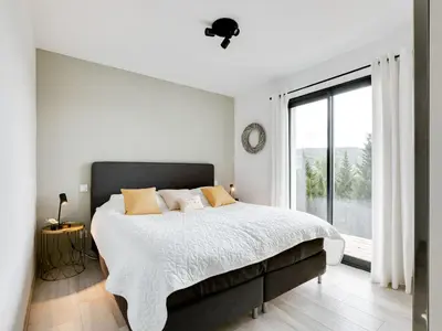 a bedroom with a large bed and a large window at Stylish villa in Beaufort with private pool in Beaufort