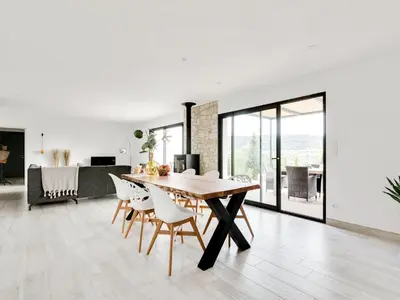 a dining room and living room with a table and chairs at Stylish villa in Beaufort with private pool in Beaufort