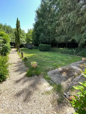 a garden with a yard with grass and trees at Residence le Petit Paradis in Labastide-Rouairoux
