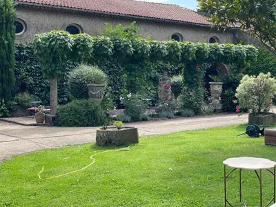 a garden with a garden hose in the grass at Residence le Petit Paradis in Labastide-Rouairoux