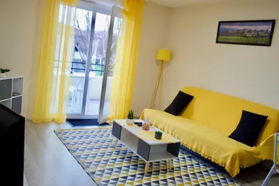 a living room with a yellow couch and a table at Appart Chrystal in Carcassonne