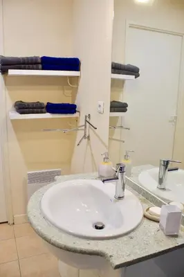 a bathroom with a white sink and a mirror at Appart Chrystal in Carcassonne