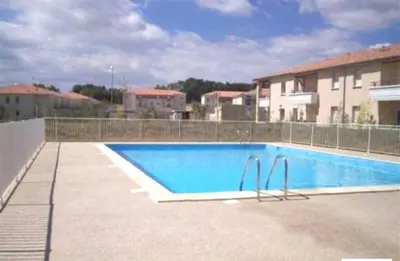 a large swimming pool in front of a building at Appart Chrystal in Carcassonne