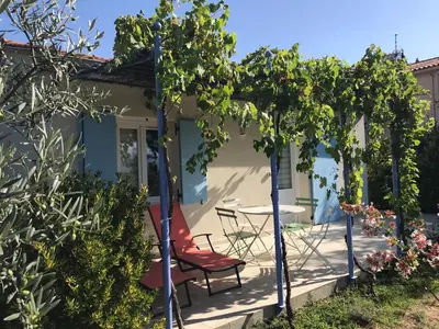 a patio with a table and chairs and trees at Maisonnette El Puy in Molitg les Bains