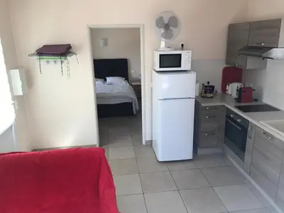 a small kitchen with a white refrigerator and a bed at Maisonnette El Puy in Molitg les Bains