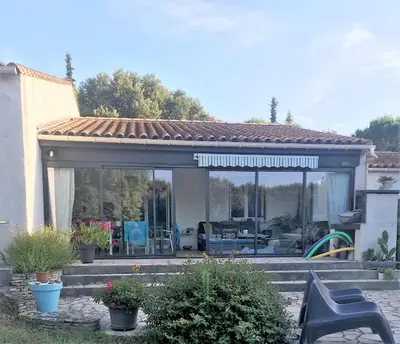 a screened in porch with a patio at Chambre d'hôte à La maison du petit bois 4 étoiles in Ventenac-Cabardès