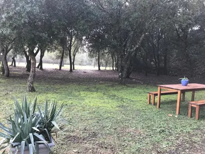a picnic table and bench in a park with trees at Chambre d'hôte à La maison du petit bois 4 étoiles in Ventenac-Cabardès