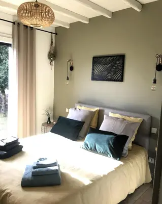 a bedroom with a large white bed with blue pillows at Chambre d'hôte à La maison du petit bois 4 étoiles in Ventenac-Cabardès