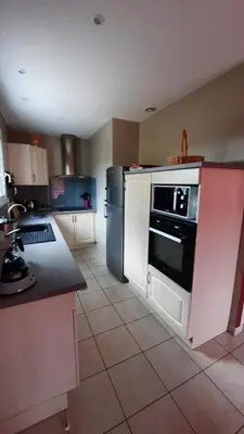 a kitchen with a black and white stove and refrigerator at Lenga doc in Prades-sur-Vernazobre