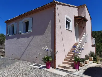a building with stairs and potted plants in front of it at Lenga doc in Prades-sur-Vernazobre