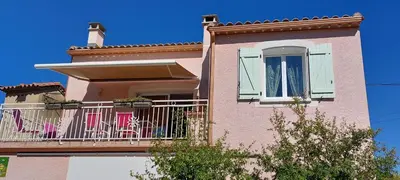 a pink building with a balcony with chairs on it at Lenga doc in Prades-sur-Vernazobre