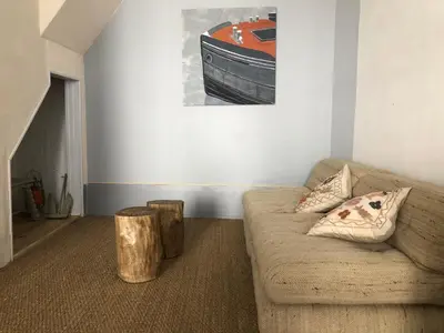 a living room with a couch and a picture of a boat at Le Petit Relais du Canal in Trèbes