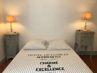 a bedroom with a bed with two night stands and two lamps at Le Petit Relais du Canal in Trèbes