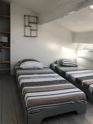 two beds sitting next to each other in a room at Le Petit Relais du Canal in Trèbes