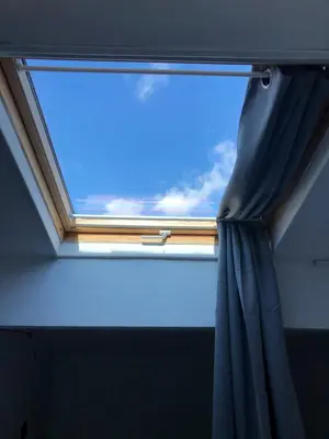a window in a room with a blue curtain at Le Petit Relais du Canal in Trèbes
