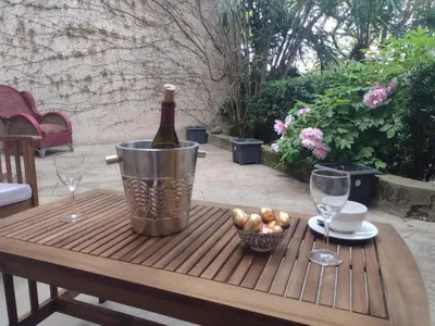 a bottle of wine in a bucket on a table with glasses at Number15 Guesthouse Carcassonne in Carcassonne