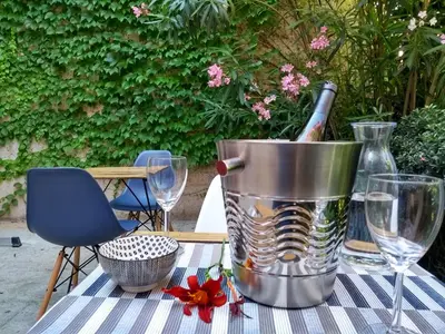 a bottle of wine in a bucket on a table with glasses at Number15 Guesthouse Carcassonne in Carcassonne